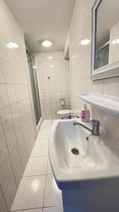 Apartamenty Ptasie Gniazdo Stare Sady في ميكووايكي: حمام أبيض مع حوض ومرآة