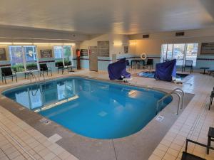 uma grande piscina com cadeiras e mesas num quarto de hotel em Residence Inn Indianapolis Airport em Indianápolis