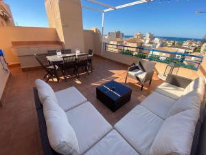 a living room with a couch and a table on a balcony at XimoApartments AP-6 ÁTICO DUPLEX CON VISTAS AL MAR Y PISCINA in Oliva