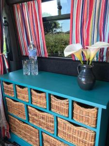 a blue table with baskets on top of it at Berty the campervan in Carbis Bay