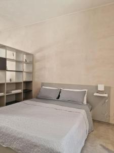 Un dormitorio con una gran cama blanca y estanterías en Charming apartment in center en Scicli