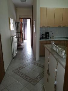 a kitchen with a tile floor and a hallway at Διαμέρισμα σε πολυκατοικία in Néa Khilí