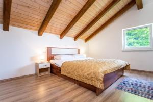 a bedroom with a bed and a wooden ceiling at Apartmani Cerovečki in Krapina