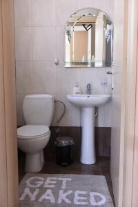 een badkamer met een toilet, een wastafel en een spiegel bij Katerina luxury suites in Elia Laconias
