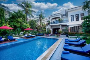 a swimming pool with chairs and a house at Peak Elite Boutique in Siem Reap