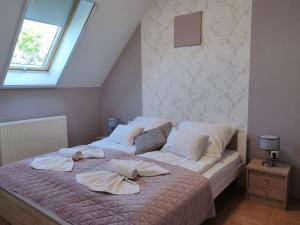 1 dormitorio con 1 cama con 2 almohadas en Kőrisfa Apartman, en Alsópáhok