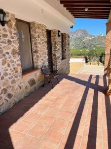 馬拉加的住宿－Habitacion rural en Alora Caminito del Rey，石头房子,在庭院设有长凳