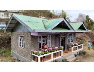 une petite maison avec un toit vert dans l'établissement Hill Home Stay, Mankhim Road, Aritar, Sikkim, à Aritar