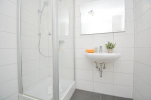a white bathroom with a sink and a shower at FO02-RI Apartment für Facharbeiter in Forchheim in Forchheim