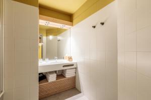 bagno con lavandino e specchio di La Cachette, Friendly Hotel & Spa ad Arc 1600