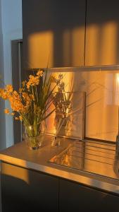 a counter with flowers in a vase on it at Ivi's apartment sea view in Vlorë