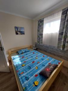 a bedroom with a large bed with blue sheets at Laurus Vendéghàz in Lovas