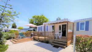 a tiny house with a deck and a patio at Coquillages & Crustacés avec Piscine Chauffée & Plage in Marennes