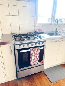 eine Küche mit einem Herd und einem Handtuch auf dem Ofen in der Unterkunft Sunny House with 5 Bedrooms(near airport) in Christchurch