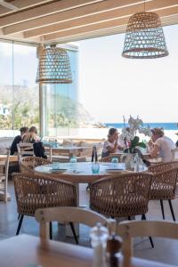 Agrari Ninemia Mykonos في Agrari: مجموعة من الناس يجلسون على الطاولات في المطعم