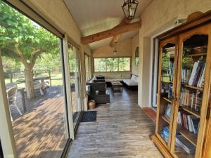 porche cerrado con puertas correderas de cristal y sala de estar en Gîte la Saume en Lambesc