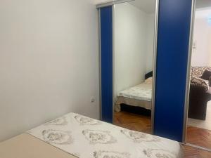 een spiegel in een kamer met een bed en een slaapkamer bij Apartman Na pjenu od mora Becici in Budva