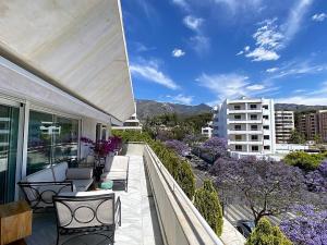 Un balcón con sillas y mesas en un edificio en SUPERIOR 3 bedroom MARBELLA center close to beach, en Marbella