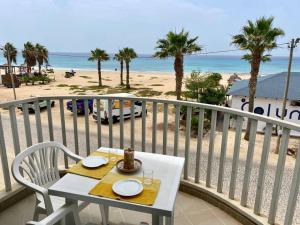 een tafel op een balkon met uitzicht op het strand bij Leme Bedje Sea View Apartments with Pool in Santa Maria