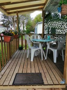 a patio with a table and chairs on a deck at Mobil home 5 pers proche d'Europa Park E020 in Boofzheim