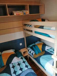 2 łóżka piętrowe w małym pokoju z: w obiekcie Mobil home 5 pers proche d'Europa Park E020 w mieście Boofzheim