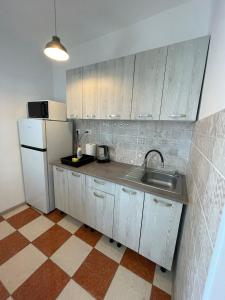 kuchnia z białymi szafkami i zlewem w obiekcie Bega Cirumvalatiunii One Room Apartment- 4 w mieście Timişoara