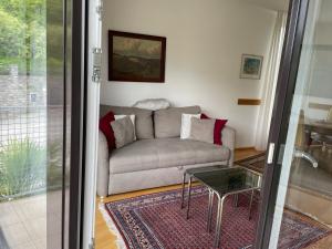 een woonkamer met een bank en een glazen tafel bij Muralto-Locarno: Collina Apt. 32 in Muralto