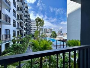 een balkon met een zwembad en palmbomen bij Jeff & Ricky Homestay 77@ Armadale Residence in Kuching