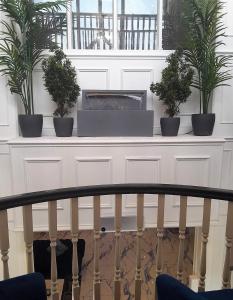 a white shelf with three potted plants on it at The Hillcrest Hotel in Widnes