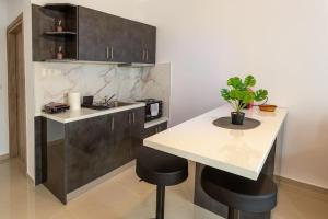 cocina con encimera y mesa con taburetes en Elegant Apartment, en Tesalónica
