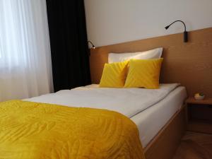 プウォツクにあるBusiness Apartment Płockのベッドルーム1室(黄色のシーツと枕のベッド1台付)
