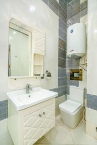 La salle de bains blanche est pourvue d'un lavabo et de toilettes. dans l'établissement City centre apartment, à Baku