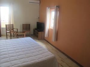 a bedroom with a white bed and a window at Auberge Le Rajah in Quatre Bornes