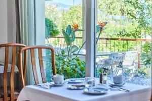 una mesa con un mantel blanco y una ventana en Kalloni Bay en Skala Kallonis