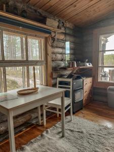a kitchen with a table and a stove at Glamping Laenlammen tila in Rovaniemi