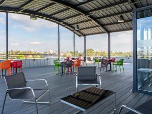 a patio with chairs and tables on a roof at B&B HOTEL Strasbourg Nord Schiltigheim Lac 4 étoiles in Schiltigheim