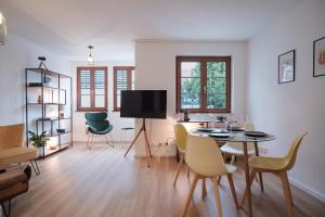 - un salon avec une table, des chaises et une télévision dans l'établissement Neues Design-Apartment, Altstadt, Business&Ferien, Küche, Netflix, à Bad Säckingen