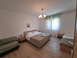 een slaapkamer met een bed, een bank en een stoel bij Apartment Felice in Novigrad Istria