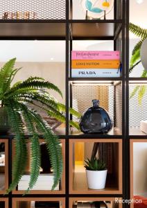 ein Bücherregal mit Büchern und einer Topfpflanze in der Unterkunft Paxton Paris MLV in Ferrières-en-Brie