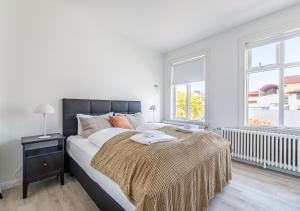 a white bedroom with a large bed and two windows at Ingolfsstræti Apartments by Heimaleiga in Reykjavík