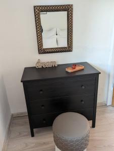 a black dresser with a mirror and a stool at Lake House Anemona in Buhalniţa