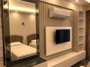 een kamer met een televisie aan de muur met een spiegel bij Mavi Villa in Demre