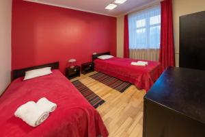 a room with two beds and a red wall at Šlokenbekas Muiža in Milzkalne +2 photos