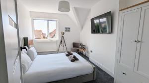 a bedroom with a bed with a teddy bear on it at Sandy Beach Apartment by Seaside Llandudno in Llandudno