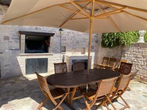 a wooden table and chairs with an umbrella at Domus Clara in Assisi