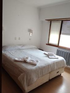 1 dormitorio con 1 cama con 2 toallas en Gran Hotel Amelia en Mar del Plata