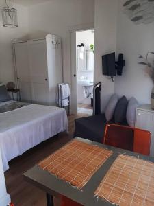a bedroom with a bed and a couch and a table at Brasil mini casa ,bagno e angolo cottura. in Ladispoli