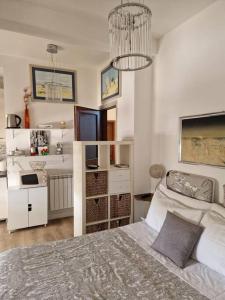 a white bedroom with a bed and a kitchen at Brasil mini casa ,bagno e angolo cottura. in Ladispoli