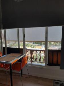 een tafel en stoelen in een kamer met een raam bij Brasil mini casa ,bagno e angolo cottura. in Ladispoli