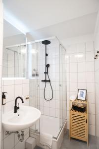 La salle de bains est pourvue d'un lavabo et d'une douche. dans l'établissement Neues Design-Apartment, Altstadt, Business&Ferien, Küche, Netflix, à Bad Säckingen